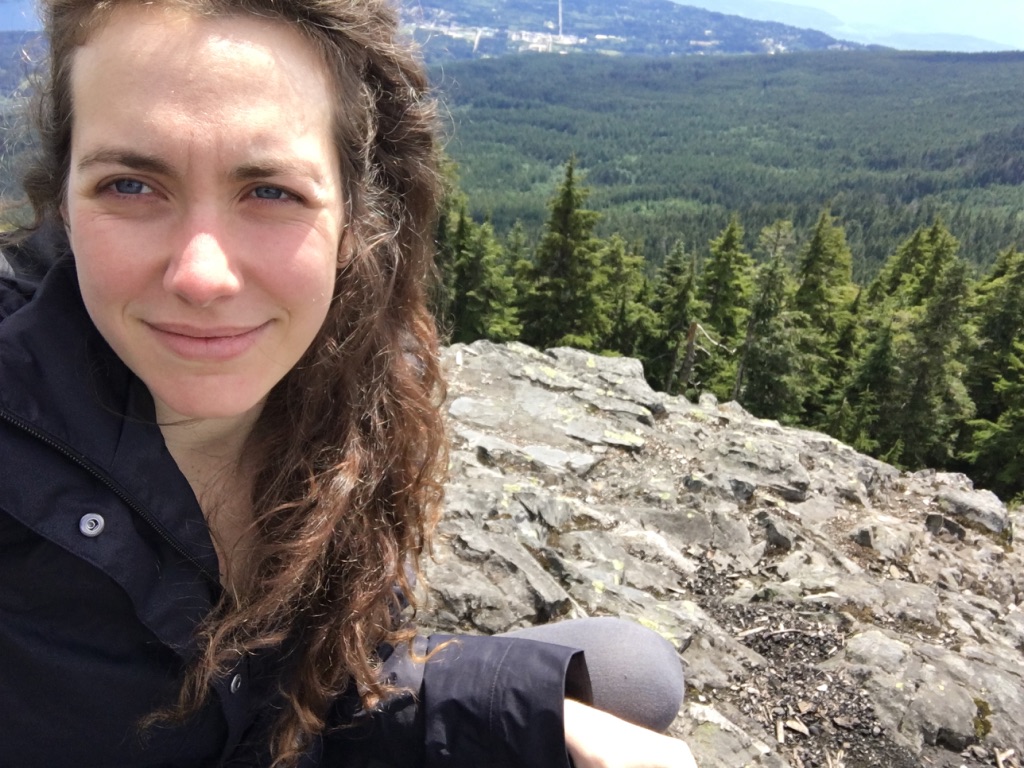 Jenna sits at the first clearing at the top of Mount Elphinstone.