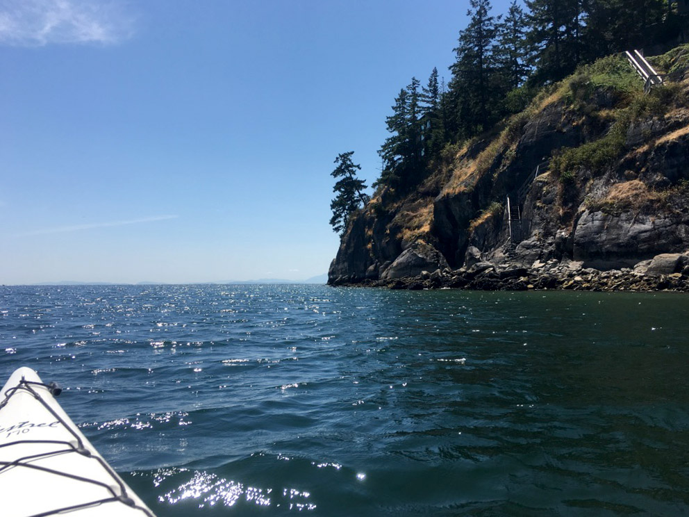 Kayaking around Keats Island on the Sunshine Coast, British Columbia. The tip of the kayak is visible on the left and Keats Island on the right.